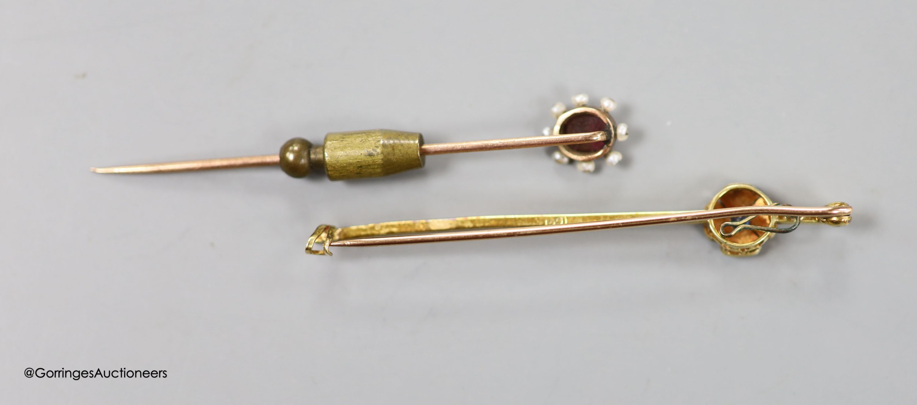 An Edwardian 15ct and gem set flower head bar brooch, 59mm, gross 3.7 grams and a yellow metal , garnet and seed pearl set stick pin, 61mm, gross weight 2.8 grams.